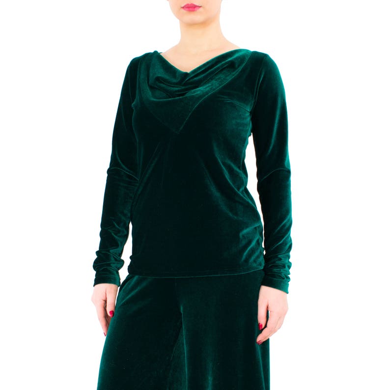 May include: A long-sleeved, emerald green velvet top with a cowl neck and a matching skirt.