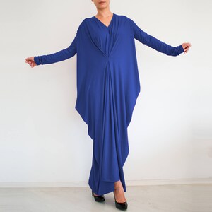 May include: A royal blue long-sleeved maxi dress with a draped, asymmetrical design. The dress has a V-neckline and a flowing silhouette.