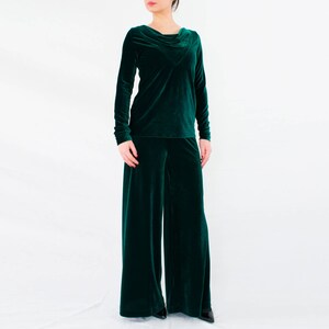 May include: A dark green velvet pantsuit with a cowl neck top and wide-leg pants.
