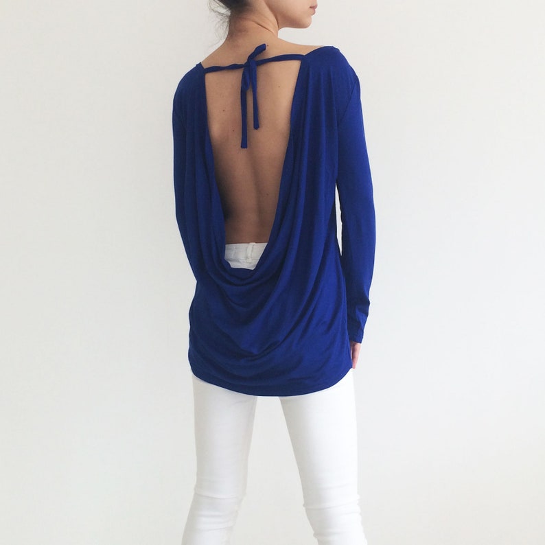 May include: A royal blue long-sleeved top with a cowl back and a tie at the neck.