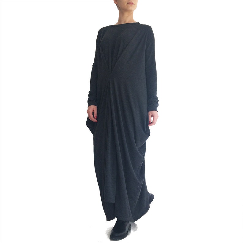 May include: A long, dark gray, loose-fitting dress with long sleeves and a gathered detail at the waist.