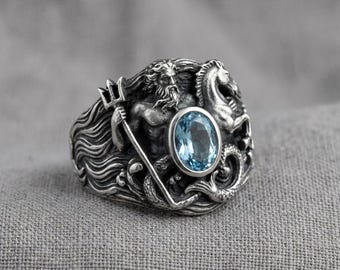 Anillo de plata Poseidón con piedra ovalada azul, símbolo de la mitología del dios del mar.