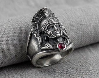Anillo con forma de casco romano, de plata y piedra roja, con diseño de guerrero.