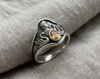 Anillo de plata con intaglio de citrino color plata, alianza llamativa con diseño de cisne y lira mitológica.