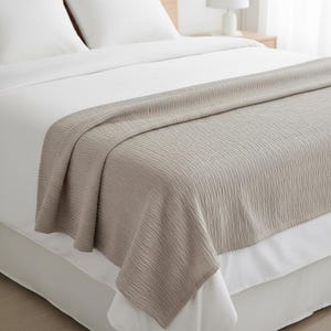 Pode incluir: Um conjunto de três canecas de cerâmica com acabamento manchado e fosco. As canecas são em tons de creme, cinza claro e cinza escuro. Cada caneca tem um design simples e minimalista.