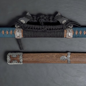 May include: A close-up of a katana sword. The handle is wrapped in black cord, with silver-coloured metal accents. The scabbard is wooden with silver-coloured metal fittings. The blade is partially visible, with a blue and brown pattern.