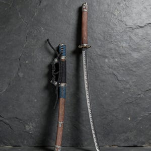 May include: A Japanese katana sword with a wooden handle and a silver-colored guard. The blade is silver and has a curved edge. The scabbard is brown with blue and black accents.