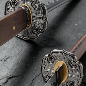 May include: Close-up of two Japanese katana swords. The swords have ornate silver tsubas with floral designs, gold accents, and dark wooden handles. The blades are sharp and reflective, with a visible hamon.