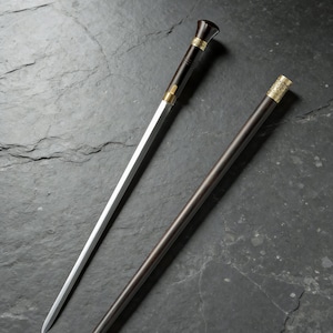 May include: Two walking canes with decorative metal accents. One cane has a dark brown shaft and a gold-colored metal tip. The other cane has a silver blade and a black handle with gold-colored metal accents.