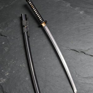 以下が含まれることがあります： 黒い柄と鞘が付いた刀。銀色の刃が特徴です。柄はひし形の模様で包まれています。鞘は刀の隣にあり、刃は視聴者の方を向いています。
