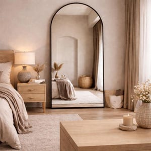 Arched floor mirror in a warm beige boho bedroom