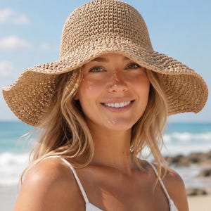 May include: A tan woven straw sun hat with a rounded crown and a wide, flexible, wavy brim. The hat features a textured, open-knit construction throughout, providing a natural, earthy appearance with a consistent light brown color tone.