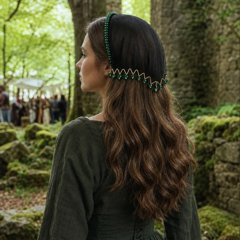 May include: A black headpiece featuring a band adorned with small green beads and a sheer black veil. The veil is accented with a gold-toned zigzag trim that hangs with dangling green teardrop-shaped beads along the lower edge of the fabric.