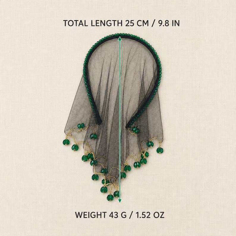 May include: A black headband with a sheer black veil featuring a scalloped edge adorned with small green beads. The item has a total length of 9.8 inches and a weight of 1.52 ounces. The text TOTAL LENGTH 25 CM / 9.8 IN and WEIGHT 43 G / 1.52 OZ is visible.