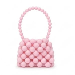 May include: A light pink beaded handbag with a matching beaded handle. The bag is constructed from numerous round beads, creating a textured surface. The handle is also made of the same pink beads. The bag is set against a white background.