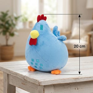 May include: A plush blue chicken toy, approximately 8 inches tall, with a red comb and wattle, yellow beak, and orange feet. The chicken has a rounded body and small wings. It is sitting on a white wooden table.