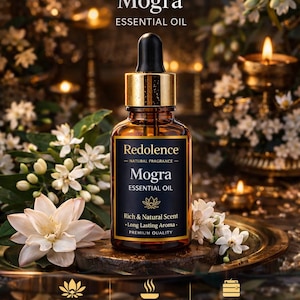 May include: A brown glass bottle of Mogra essential oil with a black dropper and gold accents. The label reads "Redolence" and "Mogra Essential Oil." White flowers and candles surround the bottle, with text that reads "100% Pure Essential Oil" and "Long Lasting Aroma."