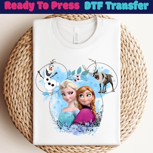 May include: White t-shirt featuring a colorful graphic of characters from the animated movie Frozen, including Elsa, Anna, Olaf, and Sven. The design is set within a Mickey Mouse-shaped outline with blue accents and the text "Ready To Press DTF Transfer" at the top.