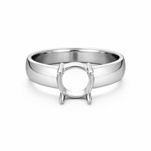May include: A polished silver ring setting with a circular centre designed to hold a gemstone. The ring has a smooth, rounded band and prongs to secure the stone. The ring is shown on a white background.