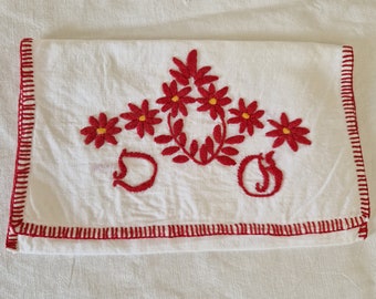 May include: White linen tea towel with red embroidered flowers and a red embroidered letter 'S' on each side.