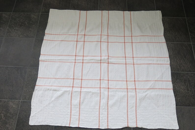 K&ouml;nnte beinhalten: Wei&szlig;e Tischdecke mit rotem Karomuster.