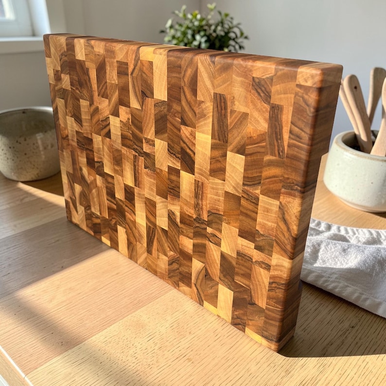 Handmade walnut end grain cutting board on kitchen table, thick butcher block chopping board made from natural walnut wood, premium wooden cutting board for kitchen, durable chef board for cutting meat, vegetables and food preparation