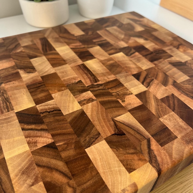 Handmade walnut end grain cutting board on kitchen table, thick butcher block chopping board made from natural walnut wood, premium wooden cutting board for kitchen, durable chef board for cutting meat, vegetables and food preparation