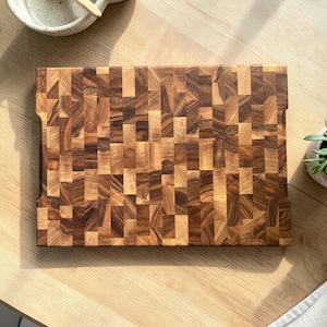 Handmade walnut end grain cutting board on kitchen table, thick butcher block chopping board made from natural walnut wood, premium wooden cutting board for kitchen, durable chef board for cutting meat, vegetables and food preparation