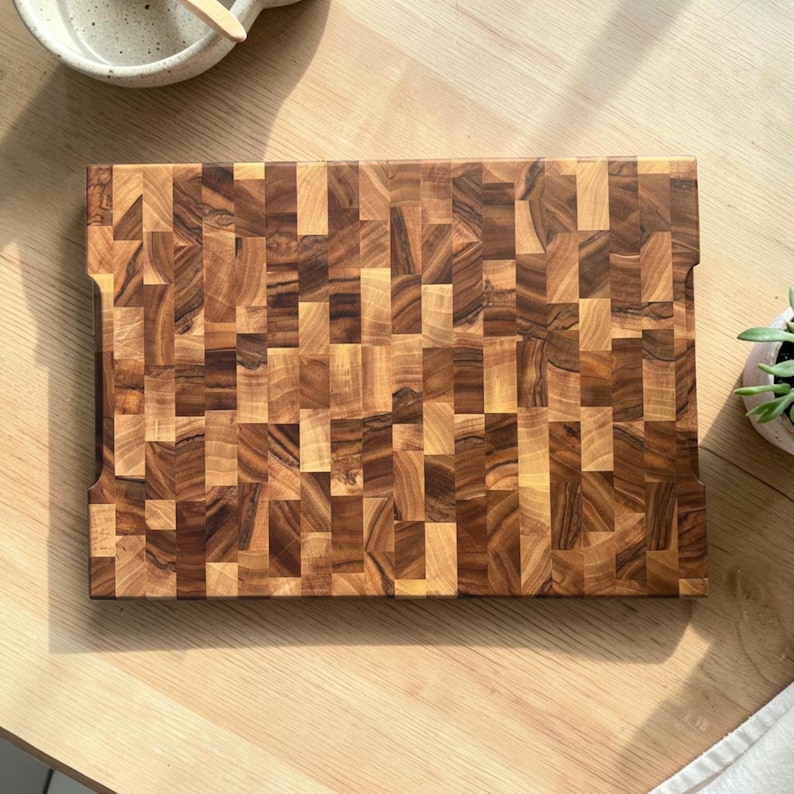 Handmade walnut end grain cutting board on kitchen table, thick butcher block chopping board made from natural walnut wood, premium wooden cutting board for kitchen, durable chef board for cutting meat, vegetables and food preparation