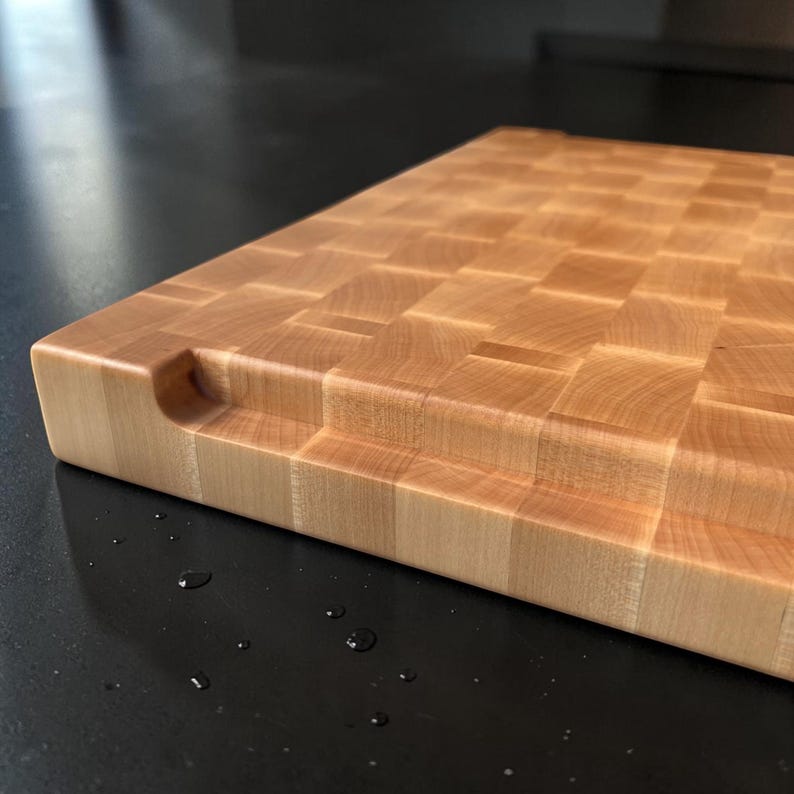 Close-up of the board corner showing the carved finger grip and smooth finished edges of the maple block