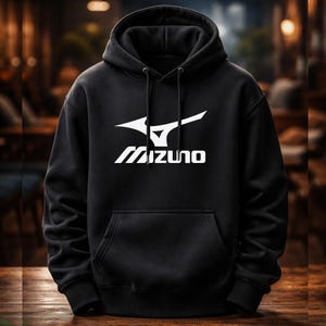 Peut inclure: Sweat à capuche noir avec le logo Mizuno blanc sur le devant. Le sweat à capuche a une capuche à cordon et une poche kangourou. Le logo Mizuno est un design stylisé d'oiseau ou d'aile avec le nom de la marque en dessous.