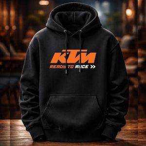 Pode incluir: Moletom preto com o logotipo KTM laranja e o texto "READY TO RACE" em branco. O moletom tem um bolso frontal e cordões no capuz.