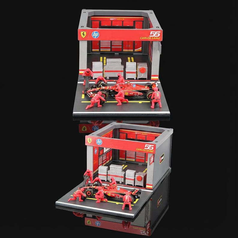 Puede incluir: Diorama en miniatura de un garaje de carreras de F&oacute;rmula 1 con un coche de carreras rojo y su equipo. El garaje tiene detalles en rojo y gris, con el n&uacute;mero "55" y el nombre "CARLOS SAINZ" mostrados. Los logotipos de HP y Ferrari tambi&eacute;n son visibles.