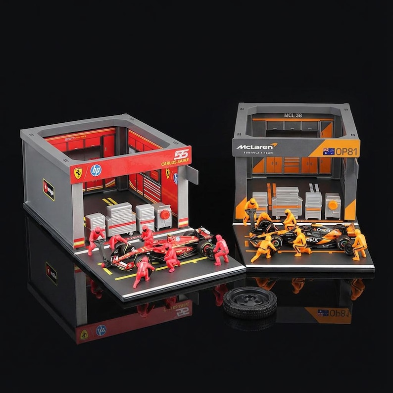 Puede incluir: Modelos en miniatura de coches de carreras de F&oacute;rmula 1 con escenarios de garaje. Un modelo presenta un coche rojo con el n&uacute;mero 55 y el nombre Carlos Sainz. El otro modelo presenta un coche negro y naranja con el logotipo de McLaren. Ambos modelos incluyen figuras en miniatura.