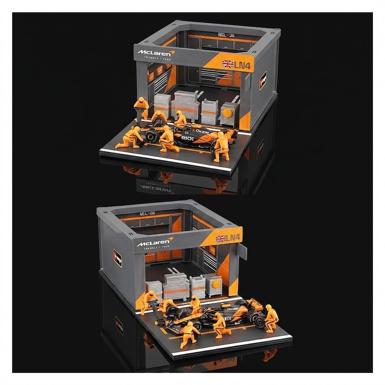 Puede incluir: Diorama en miniatura de un garaje McLaren de F&oacute;rmula 1 con un coche de carreras negro y naranja y varias figuras peque&ntilde;as de color naranja. El garaje es gris con detalles en naranja y el logotipo de McLaren.