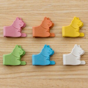 May include: Six colorful cat-shaped clips in pink, orange, yellow, green, blue, and white. The clips are made of plastic and have a cute cat design.