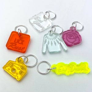 Può includere: Sei marcatori di punto in acrilico colorati con diversi design. I marcatori presentano una fetta di pizza, un maglione, una rosa, un quadrato con il testo "lick rust", un quadrato con il testo "oh glass" e un rettangolo con il testo "Ew, Dadish".