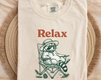 Relájate, nada está bajo control. Camiseta divertida de mapache para acampar. Regalo ideal.
