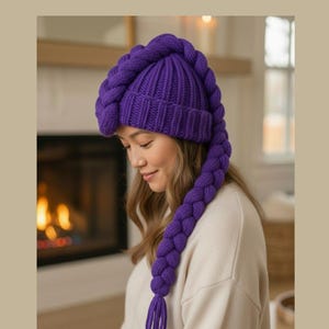 May include: A vibrant purple knit hat with a long, braided extension. The hat is a deep violet color and features a ribbed design on the main cap. The braided extension hangs down, adding a unique and whimsical touch to the winter accessory.