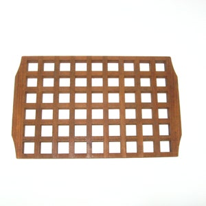 May include: A rectangular wooden tray with a grid pattern. The tray is made of light brown wood and has a slightly rounded edge.