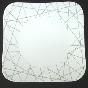 May include: White square ceramic plate with a brown line design around the edge.