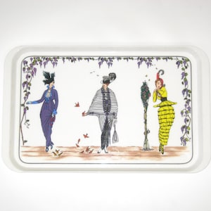May include: Rectangular serving tray with a white border and a decorative illustration. The illustration features three figures in vintage attire, with a purple vine border. The figures are in purple, black, white, and yellow. The tray is likely used for serving food or drinks.