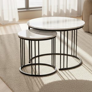 May include: Two round nesting coffee tables. The tabletops have a white marble design. The tables have black metal frames with vertical bars and a circular base. The tables are on a light beige carpet.