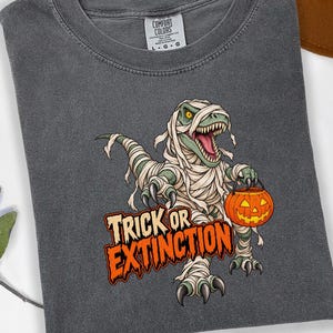 Camiseta de Halloween "Truco o Extinción" con diseño de momia y T-Rex. Camiseta de dinosaurio aterradora. Tallas S-4XL.