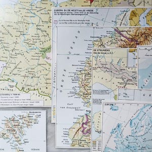 Könnte beinhalten: Eine Sammlung überlappender historischer und geografischer Papierkarten, die verschiedene Regionen wie Europa, die Weimarer Republik und den Golf von Guayaquil zeigen. Die Karten enthalten gedruckten Text, Grenzen und topografische Details in gedeckten Farben.