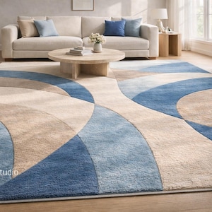 May include: A large, modern area rug with a curved pattern in shades of blue, beige, and tan. The rug is in a living room setting, complementing the neutral-toned furniture and decor.