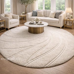 Hand tufted round ivory wool rug in modern living room with beige sofa