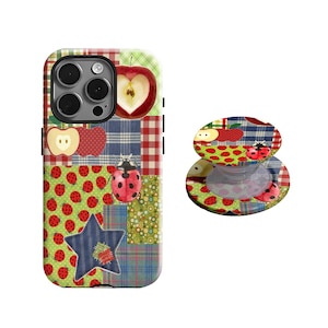 May include: A patterned phone case and phone grip with apple and ladybug motifs. The case features a patchwork design with red, green, blue, and yellow patterns, including gingham, polka dots, and a star. The grip echoes the case's design.