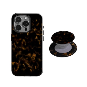 May include: A black phone case and matching phone grip with a tortoiseshell pattern. The case has a glossy finish and cutouts for the camera and buttons. The phone grip is round and has a white base.
