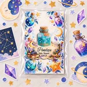 Pode incluir: Um cartão retangular numa manga de plástico transparente com um tema celestial em aguarela com frascos de poções, cristais, luas e estrelas. O centro apresenta um frasco azul com o rótulo Cosmic Dust e o texto Penelope Baby Shower 12.19.25.